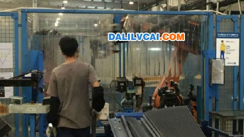 东莞工人与机器人合作完成产品的组装生产